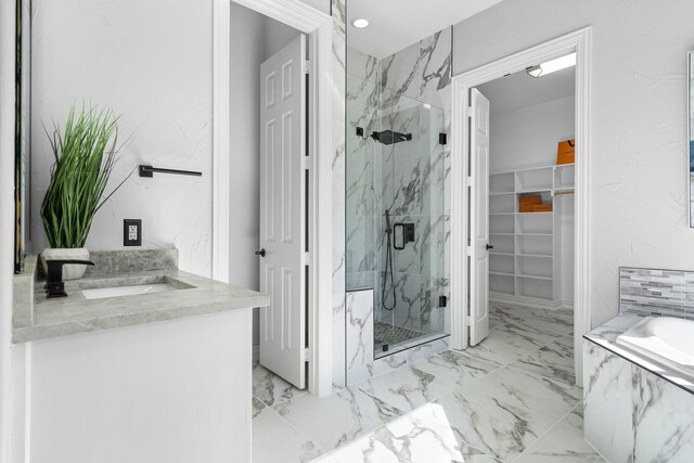 bathroom featuring a walk in closet, marble finish floor, and a marble finish shower