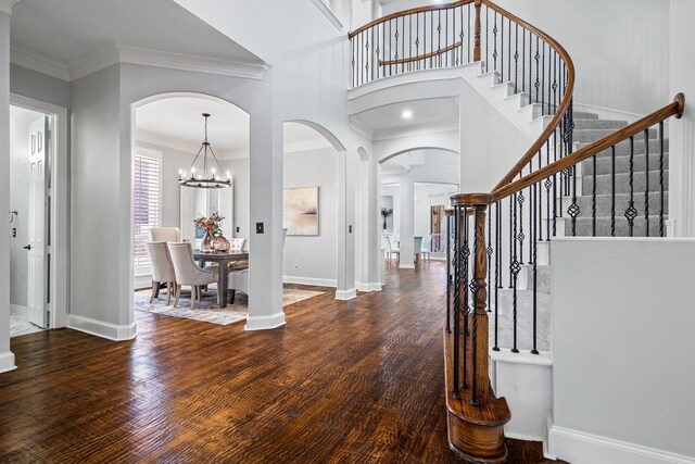 foyer entrance with ornamental molding, baseboards, and wood finished floors