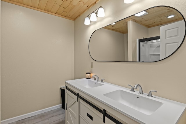 bathroom featuring wood finished floors, wood ceiling, baseboards, and a sink