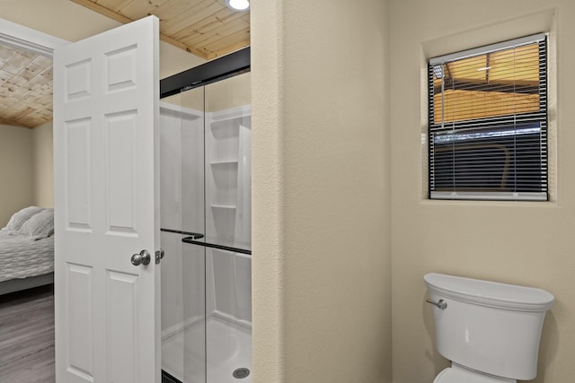 bathroom featuring wooden ceiling, toilet, wood finished floors, and a shower stall