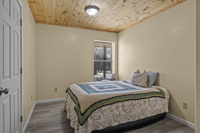 bedroom with wood finished floors, wood ceiling, and baseboards