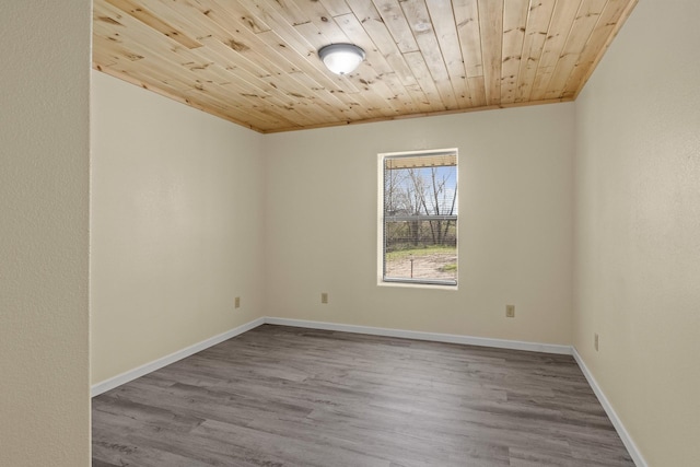 empty room featuring baseboards, wood finished floors, and wooden ceiling