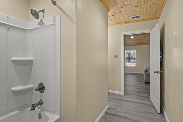 bathroom featuring visible vents, wood finished floors, tub / shower combination, baseboards, and wood ceiling