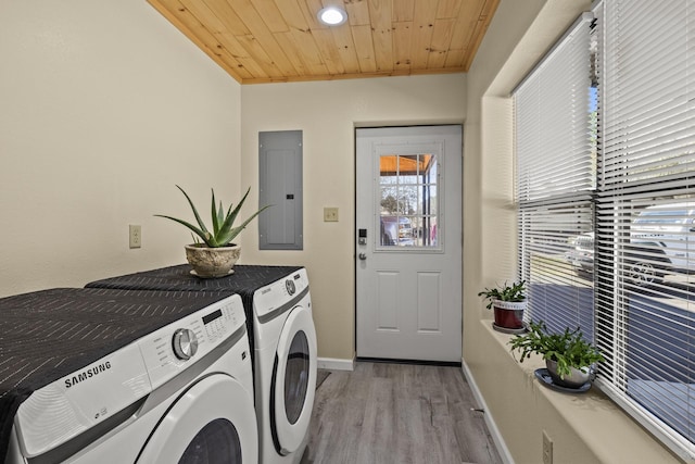 laundry area featuring light wood finished floors, laundry area, electric panel, wood ceiling, and washer and clothes dryer