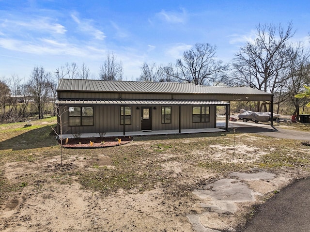 back of house with a standing seam roof, a porch, board and batten siding, and metal roof