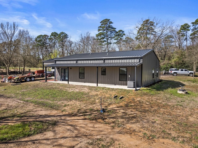 rear view of property featuring a standing seam roof, french doors, and metal roof