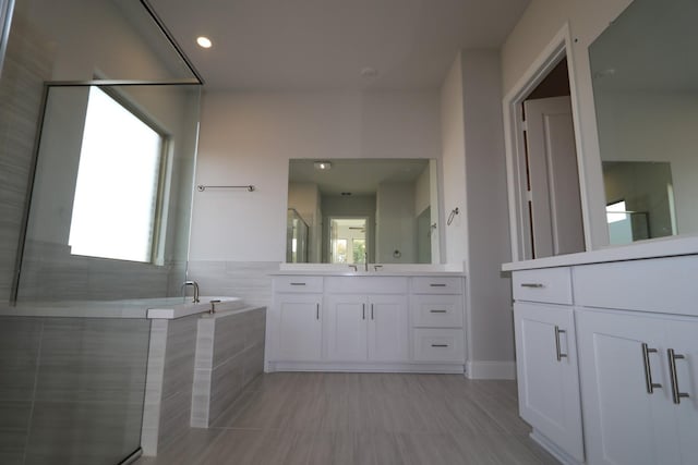 full bath with vanity, a shower stall, a bath, and a wealth of natural light