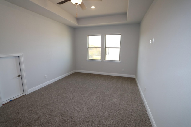 spare room with a tray ceiling, recessed lighting, carpet flooring, baseboards, and ceiling fan