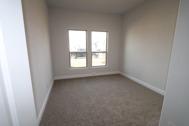 unfurnished room with carpet flooring and baseboards