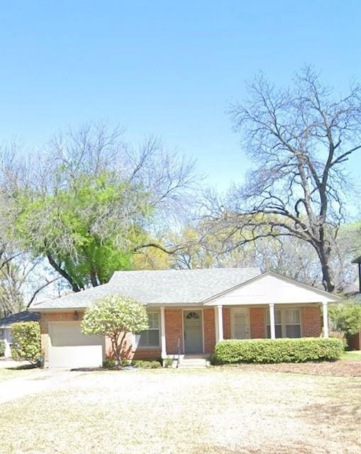 view of front facade with an attached garage, brick siding, and driveway