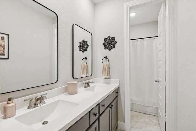 full bathroom featuring double vanity and a sink