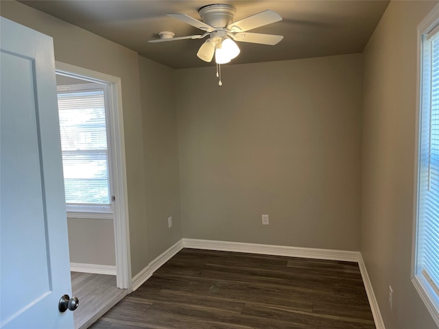 unfurnished room featuring baseboards, dark wood-style floors, and a ceiling fan