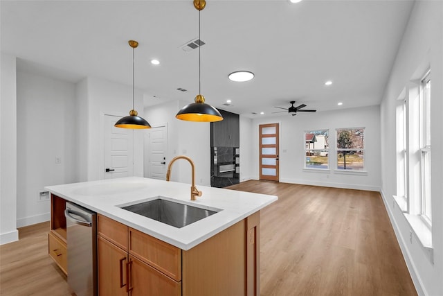 kitchen with visible vents, a sink, light countertops, pendant lighting, and dishwasher