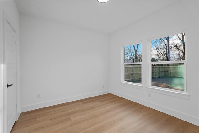 spare room featuring light wood-style flooring and baseboards