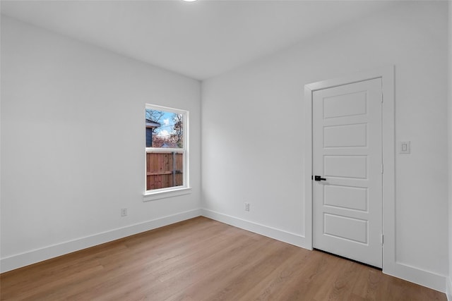 empty room with light wood-type flooring and baseboards