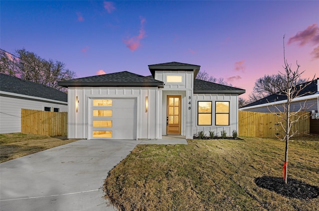 view of front facade with board and batten siding, concrete driveway, an attached garage, and fence