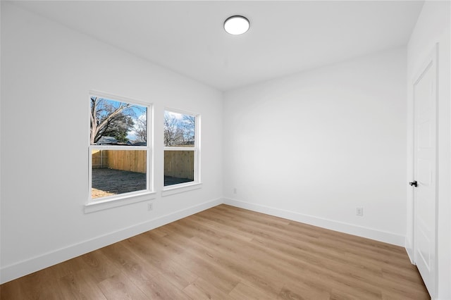 unfurnished room featuring baseboards and light wood-style floors