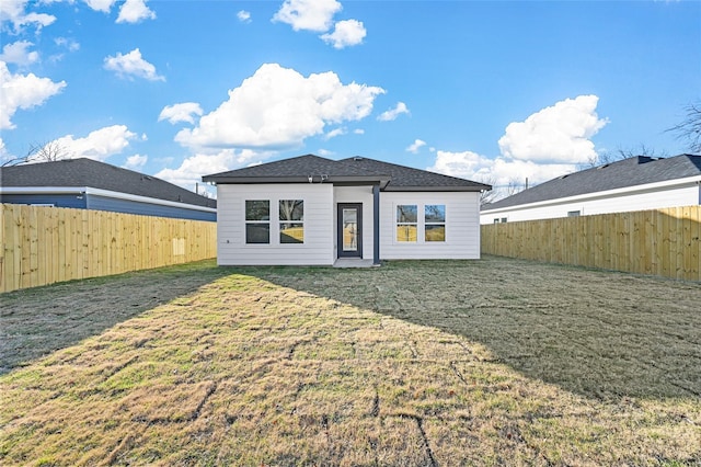 back of house featuring a lawn and a fenced backyard