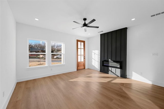 unfurnished living room with visible vents, baseboards, a fireplace, recessed lighting, and light wood-type flooring