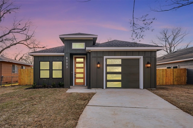 view of front of house featuring a garage, board and batten siding, driveway, and fence