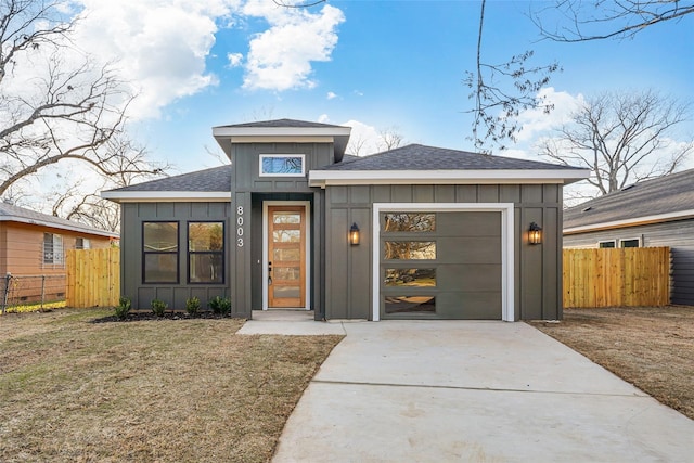 view of front of property featuring board and batten siding, driveway, a garage, and fence