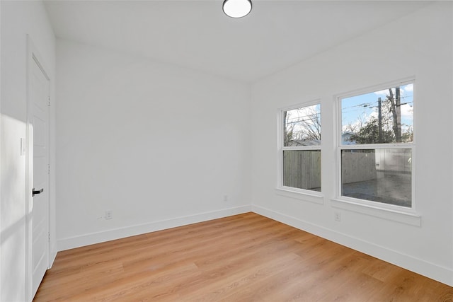 unfurnished room featuring baseboards and light wood-style flooring