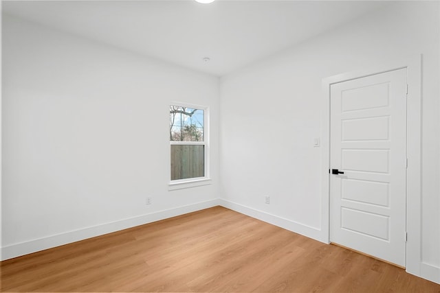 empty room with baseboards and light wood-type flooring