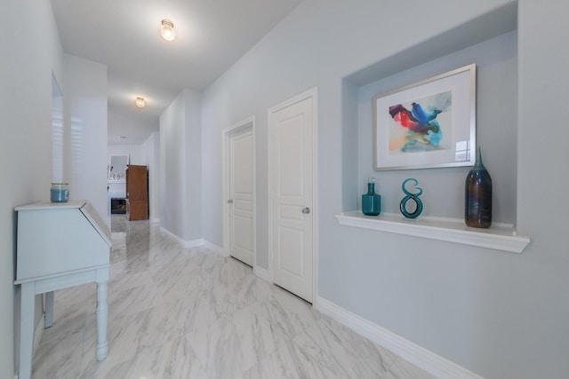 hallway with baseboards and marble finish floor