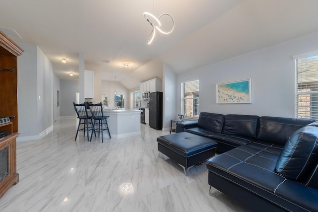 living room with a wealth of natural light, visible vents, marble finish floor, and baseboards