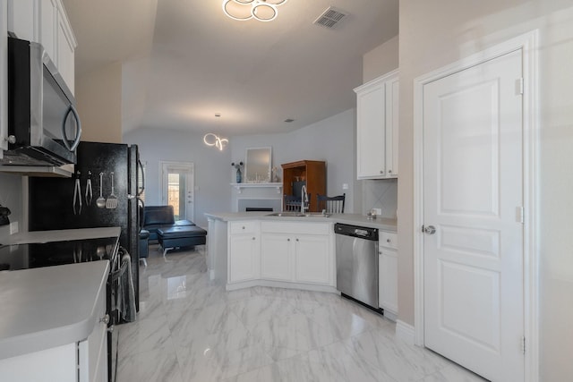 kitchen with marble finish floor, appliances with stainless steel finishes, light countertops, and a peninsula