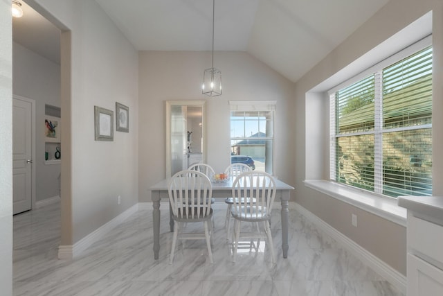 dining area with baseboards, lofted ceiling, and marble finish floor