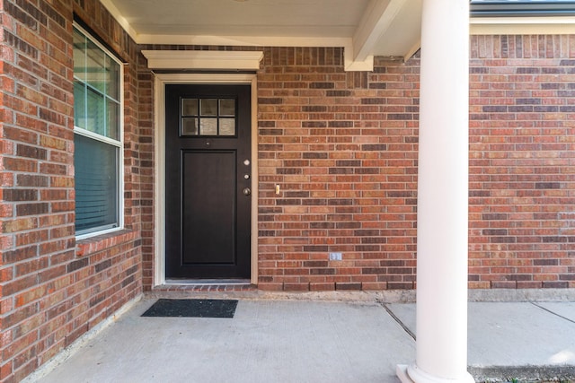 view of exterior entry with brick siding