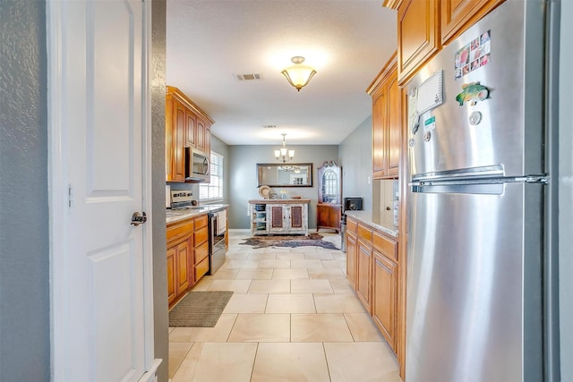 kitchen with visible vents, a chandelier, decorative light fixtures, light tile patterned floors, and appliances with stainless steel finishes