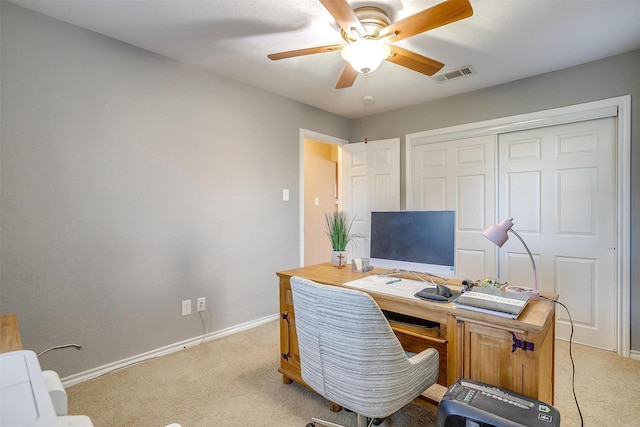 office with visible vents, ceiling fan, light colored carpet, and baseboards