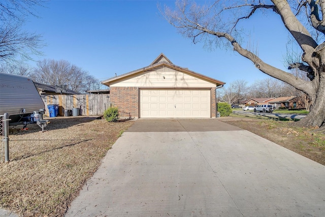 view of home's exterior with brick siding, driveway, a garage, and fence