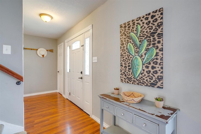 foyer featuring wood finished floors and baseboards