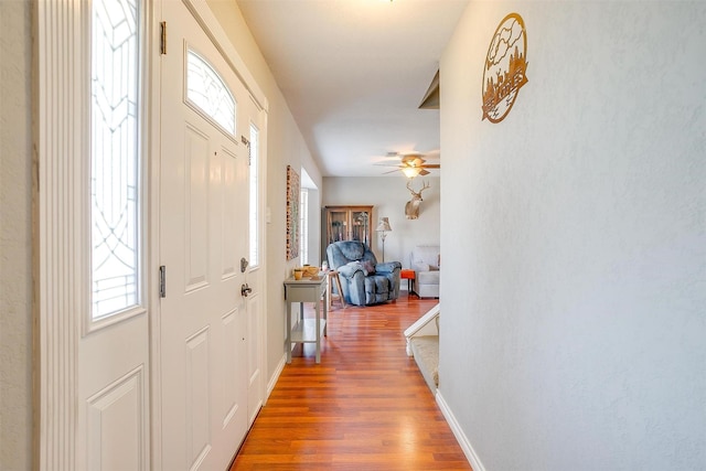 entrance foyer featuring a ceiling fan, wood finished floors, and baseboards