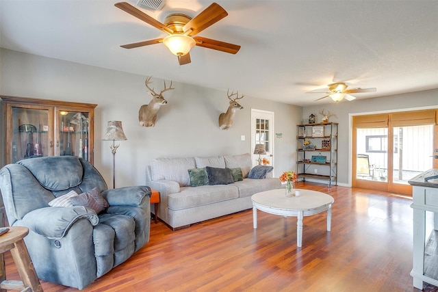 living room with a ceiling fan and wood finished floors