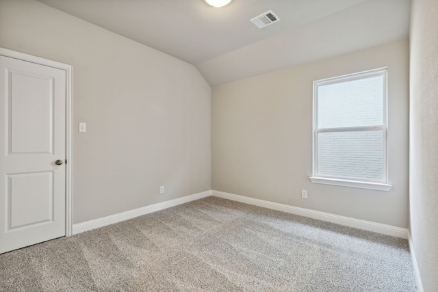 spare room with visible vents, baseboards, carpet, and lofted ceiling