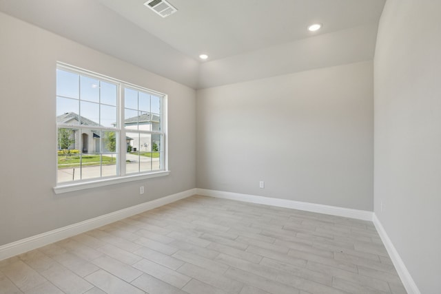 empty room featuring light wood-style flooring, recessed lighting, baseboards, and visible vents