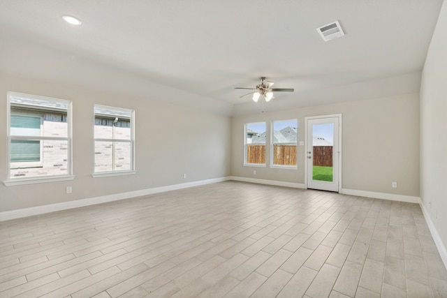 empty room with plenty of natural light, visible vents, a ceiling fan, and baseboards