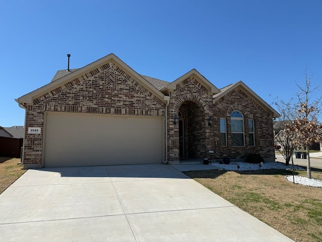 view of front of property with concrete driveway, a garage, and brick siding