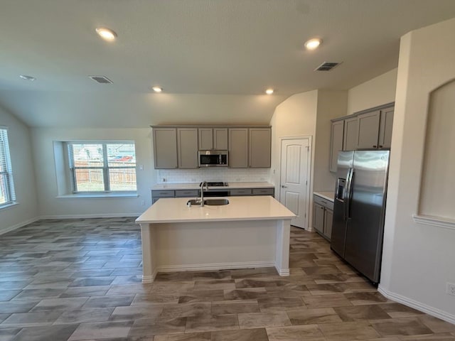 kitchen with a sink, visible vents, appliances with stainless steel finishes, and gray cabinets