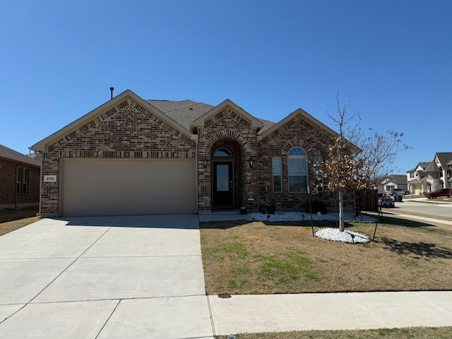 view of front of property with a front yard, driveway, roof with shingles, an attached garage, and brick siding