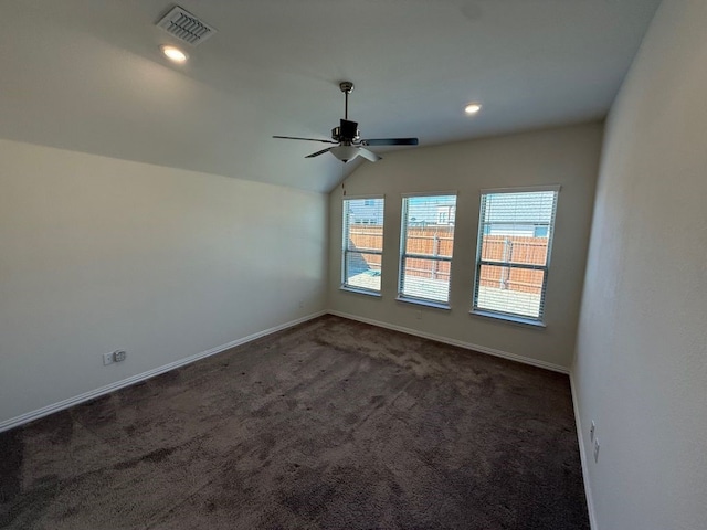 carpeted empty room with baseboards, lofted ceiling, visible vents, and ceiling fan