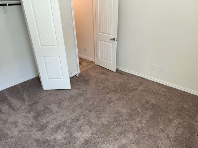 unfurnished bedroom featuring a closet, baseboards, and carpet floors