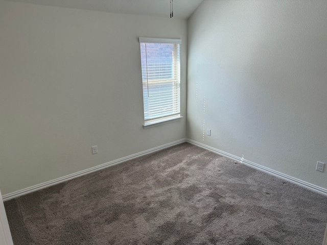 empty room featuring baseboards and carpet