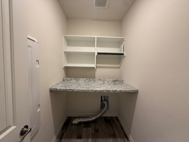 laundry room featuring laundry area, wood finished floors, visible vents, and baseboards