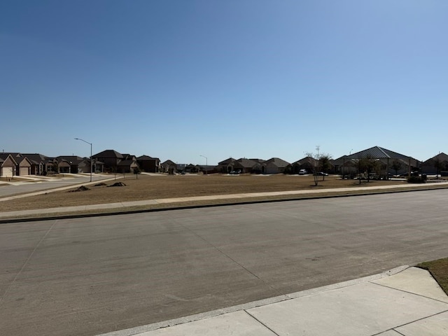 view of road featuring a residential view, curbs, and sidewalks