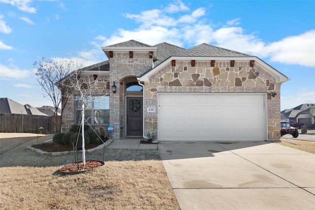 view of front of house with stone siding, fence, concrete driveway, a garage, and brick siding